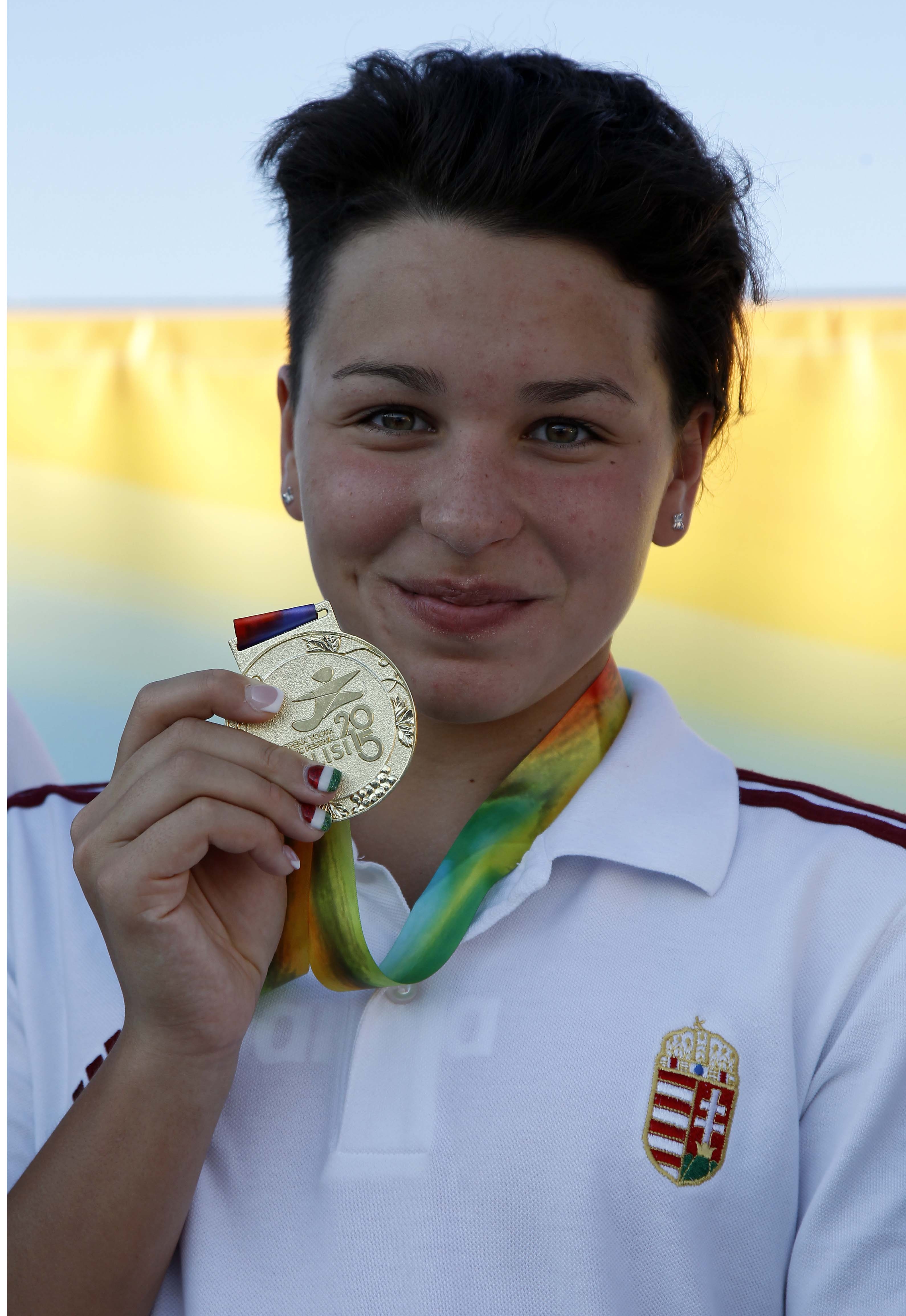 Késely Ajna aranyérmét mutatja a 400 méteres gyorsúszás döntője után